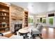 Cozy living room features a stone fireplace, built-in shelving, and a dining area at 12775 Horizon Trl, Castle Pines, CO 80108