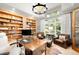 Bright office with built-in bookshelves, a desk, and leather chairs at 12775 Horizon Trl, Castle Pines, CO 80108