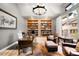 Well-lit office featuring built-in bookshelves, a desk, and leather chairs at 12775 Horizon Trl, Castle Pines, CO 80108