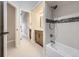 Bright bathroom featuring a vanity with a mirror, a bathtub with white tile, and access to additional rooms at 15224 W 73Rd Ave, Arvada, CO 80007
