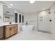 Elegant bathroom featuring a soaking tub, glass-enclosed shower, and stylish vanity with large mirror at 15224 W 73Rd Ave, Arvada, CO 80007