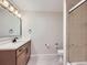 Bright bathroom featuring vanity with wood cabinet, a shower, and a large mirror at 15224 W 73Rd Ave, Arvada, CO 80007