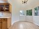 Breakfast nook with bright windows and warm lighting features wood cabinets with glass panels at 15224 W 73Rd Ave, Arvada, CO 80007
