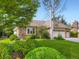 Well-maintained home with a lush green lawn, mature trees, and a colorful garden at 15224 W 73Rd Ave, Arvada, CO 80007