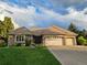 Charming single-story brick home with a well-manicured lawn and a spacious three-car garage at 15224 W 73Rd Ave, Arvada, CO 80007