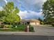 Well-kept brick home with a three-car garage, green lawn and mailbox by the curb at 15224 W 73Rd Ave, Arvada, CO 80007
