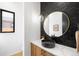 Modern powder room featuring a vessel sink, round mirror, unique tile backsplash, and stylish lighting at 1241 S Garfield St, Denver, CO 80210