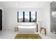 Bright bathroom featuring a soaking tub, modern fixtures, a large window, and minimalist decor at 1241 S Garfield St, Denver, CO 80210