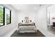 Bright, minimalist bedroom with a cozy bed, simple decor, and ensuite bathroom entrance at 1241 S Garfield St, Denver, CO 80210