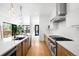 Bright kitchen featuring hardwood floors, stainless steel appliances, a spacious island and modern lighting at 1241 S Garfield St, Denver, CO 80210