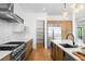 Open kitchen featuring stainless steel appliances, custom cabinetry, and quartz countertops at 1241 S Garfield St, Denver, CO 80210