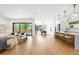 Open-concept living room with natural light, hardwood floors, and a seamless flow to the dining area and kitchen at 1241 S Garfield St, Denver, CO 80210