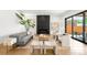 Bright living room featuring a fireplace, sleek furniture, light wood floors, and access to the outside patio at 1241 S Garfield St, Denver, CO 80210