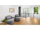 Upstairs sitting area with hardwood floors, modern chairs, side table, art and window at 1241 S Garfield St, Denver, CO 80210