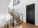 Staircase with sleek black railings, modern lighting fixtures and a large black front door at 1241 S Garfield St, Denver, CO 80210