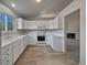 White kitchen with tile floor and stainless steel appliances at 6442 Yank Ct # C, Arvada, CO 80004