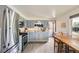 A well-lit kitchen area featuring stainless steel appliances, gray cabinets, and an adjacent eating area at 755 Braun St, Lakewood, CO 80401