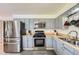 A kitchen with light blue cabinets, stainless steel appliances, and a sink area with tile backsplash at 755 Braun St, Lakewood, CO 80401