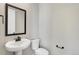 Simple powder room with pedestal sink, black fixtures, and a dark-framed mirror at 1525 E 3Rd Ave, Longmont, CO 80501