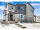 Charming two-story home featuring modern gray siding, brick accents, and a welcoming front porch at 1525 E 3Rd Ave, Longmont, CO 80501