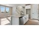 Open kitchen with granite island, stainless steel dishwasher, and hardwood floors, connecting to the staircase at 1525 E 3Rd Ave, Longmont, CO 80501