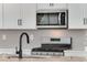 Close-up of a modern kitchen with stainless steel microwave, gas range, and granite countertops at 1525 E 3Rd Ave, Longmont, CO 80501
