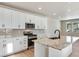 Modern kitchen with white cabinetry, granite countertops, stainless appliances, and an island with a sink at 1525 E 3Rd Ave, Longmont, CO 80501