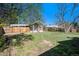 Large backyard with wooden fence perimeter, storage shed, small garden area, and covered porch seating at 4196 S Pennsylvania St, Englewood, CO 80113