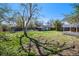 Expansive backyard with garden beds, mature trees, a lush lawn, and a covered back porch at 4196 S Pennsylvania St, Englewood, CO 80113