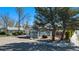 Quaint blue house with a covered porch, mature trees, and rock landscaping at 4196 S Pennsylvania St, Englewood, CO 80113