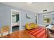Open living room with hardwood floors, yellow seating, and neutral-toned walls and connected bedroom at 4196 S Pennsylvania St, Englewood, CO 80113