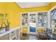 Charming sunroom featuring a storage unit, bright yellow walls, and plenty of natural light at 4196 S Pennsylvania St, Englewood, CO 80113