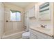 Classic bathroom featuring a tub/shower combo, white tile, and a vanity sink at 1049 Galena St, Aurora, CO 80010