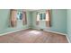 Bright bedroom featuring two large windows, neutral carpet, and fresh teal paint at 1049 Galena St, Aurora, CO 80010