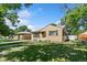 Quaint single-story home featuring green shutters, a manicured lawn and mature trees at 1049 Galena St, Aurora, CO 80010