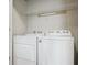 White, front-loading washer and dryer in a dedicated laundry space, conveniently equipped with an overhead storage shelf at 10184 Park Meadows Dr # 1303, Lone Tree, CO 80124
