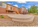 A concrete patio with wooden deck steps highlights the backyard of this cozy home under a beautiful blue sky at 1100 Columbine Way, Erie, CO 80516