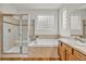 The bright bathroom features a glass enclosed shower and large soaking tub at 1100 Columbine Way, Erie, CO 80516