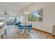 Open-plan dining area with modern table set, chandelier and scenic window views to the outdoors at 1100 Columbine Way, Erie, CO 80516