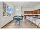 Open-plan dining area with modern table set adjacent to a kitchen with an eat-in island at 1100 Columbine Way, Erie, CO 80516