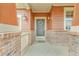 Close up of a charming front porch with brick accents, a decorative wreath on the front door, and vintage-style lighting at 1100 Columbine Way, Erie, CO 80516