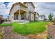 Charming home featuring a well-maintained lawn, a covered porch with stone pillars, and a small deck at 6335 E 143Rd Dr, Thornton, CO 80602