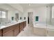This bathroom is equipped with double sinks, separate tub and shower, and closet at 6335 E 143Rd Dr, Thornton, CO 80602
