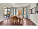 Bright dining area with hardwood floors, large windows, and a sliding door to the backyard at 6335 E 143Rd Dr, Thornton, CO 80602