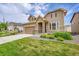 Attractive two-story home featuring stone accents, an attached garage and lush green lawn at 6335 E 143Rd Dr, Thornton, CO 80602
