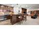Wet bar with wood cabinets, barstool seating, and a mini-refrigerator at 9151 E Harvard Ave, Denver, CO 80231