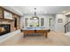 Spacious basement featuring a pool table and brick fireplace at 9151 E Harvard Ave, Denver, CO 80231