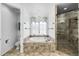Bright bathroom features a luxurious soaking tub, a shower, and tiled surround at 9151 E Harvard Ave, Denver, CO 80231