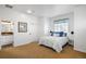 Bright bedroom with a blue and white bedspread, carpet flooring, and ensuite bathroom at 9151 E Harvard Ave, Denver, CO 80231