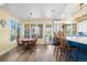 Sunlit breakfast nook features wood floors, a round table and backyard views at 9151 E Harvard Ave, Denver, CO 80231